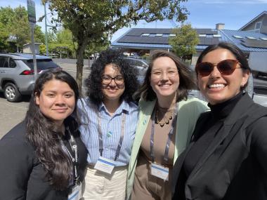 Four people smile at the camera, ready to attend an event.