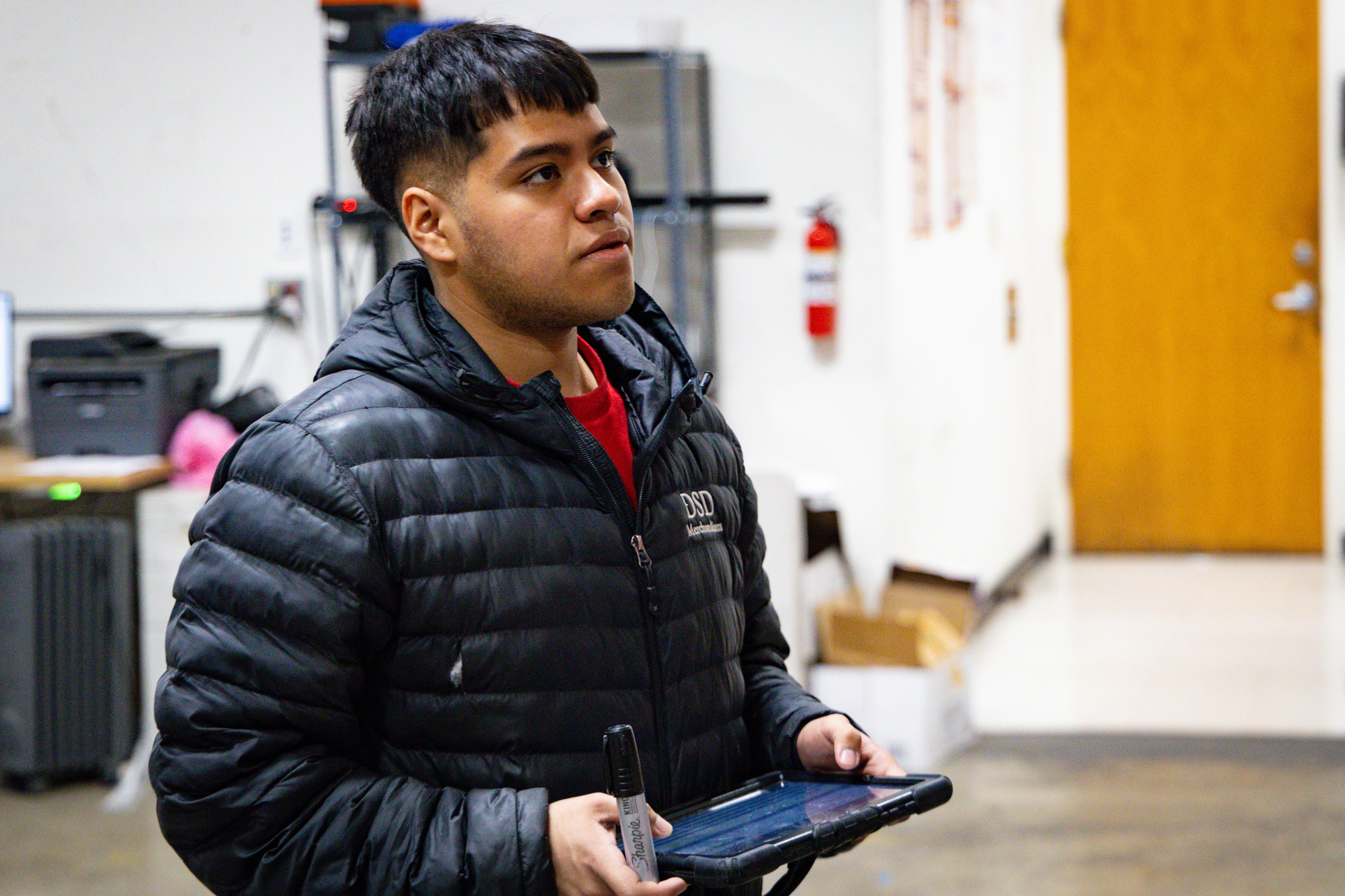 Person with an iPad in their hand looking at stock to the right of them.