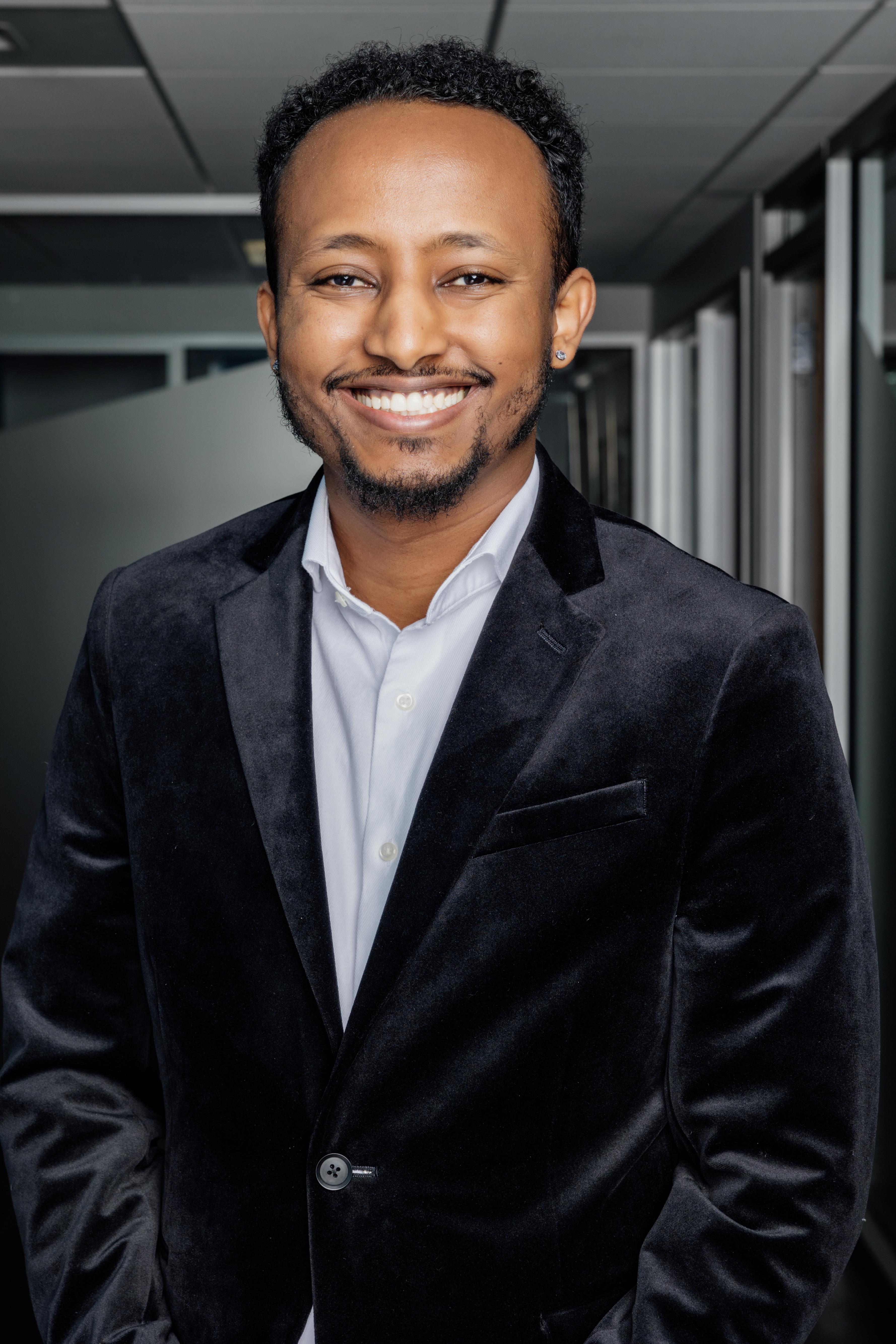 Yonas, wearing a suit, smiling at the camera. 